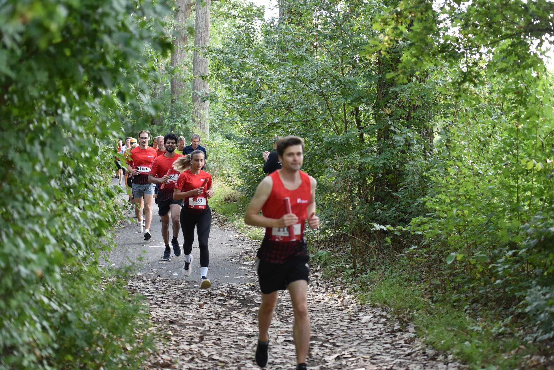 Teilnehmende laufen gemeinsam auf einem Waldweg beim FI Fun Run 2026